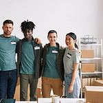 diverse team volunteers smiling camera embracing during help donation event copy space