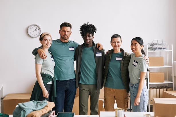 diverse team volunteers smiling camera embracing during help donation event copy space