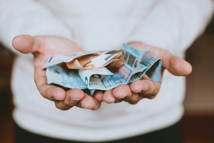 Hands holding crumpled Euro banknotes, concept of financial inheritance tax.