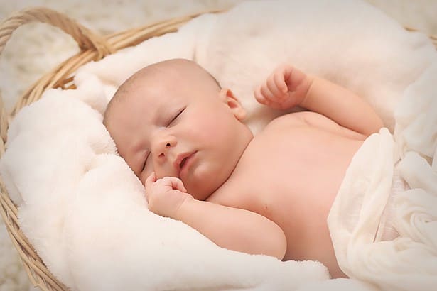 newborn sleeping on sleep sack